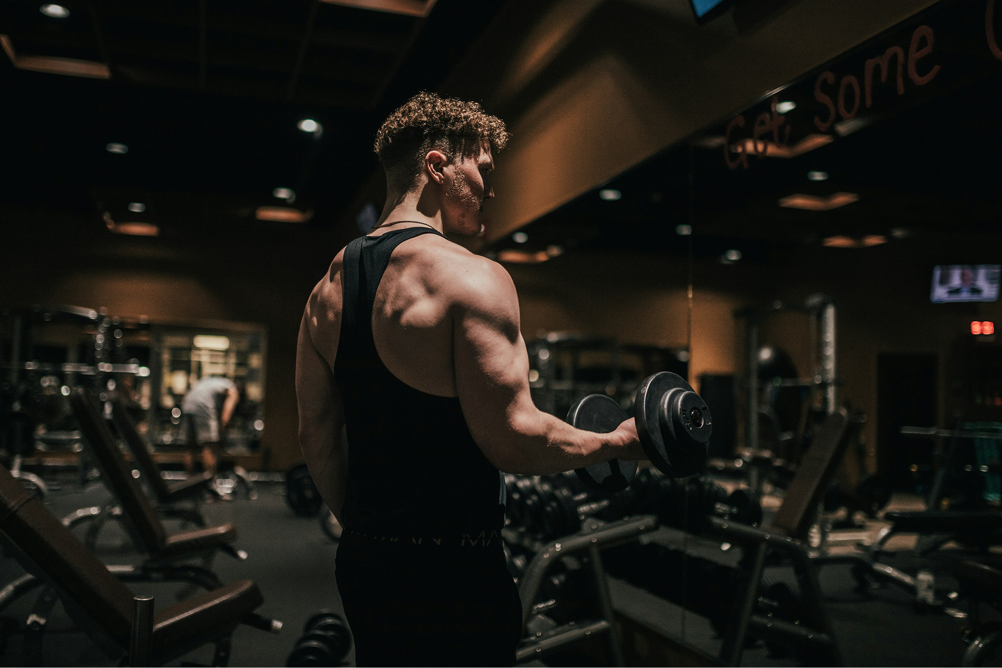 Athlete performing a dumbbell curl in a gym